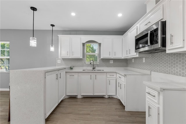 kitchen featuring a wealth of natural light, white cabinets, and hanging light fixtures