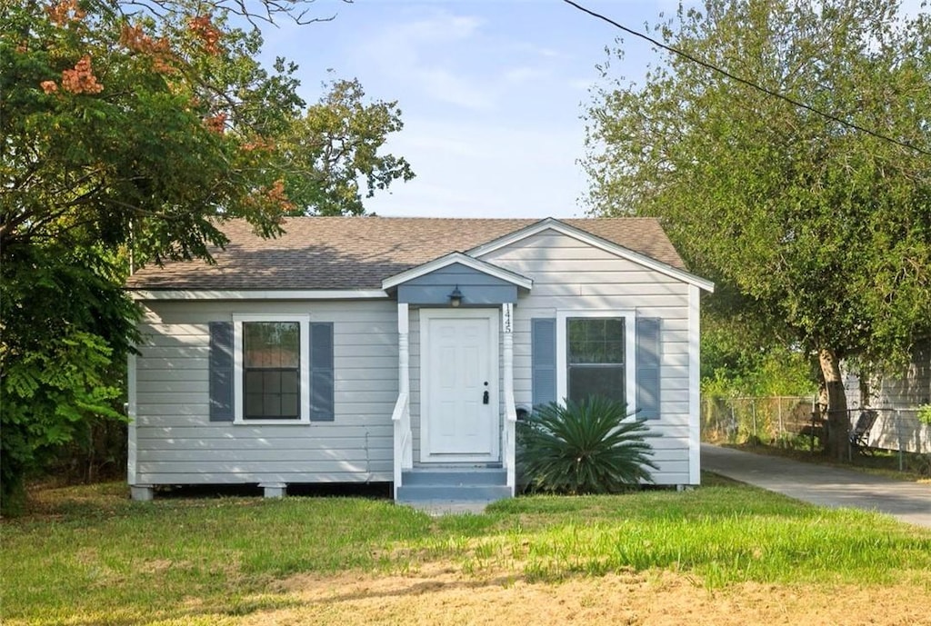 bungalow-style home with a front lawn