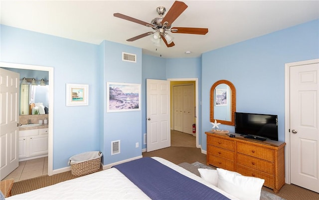 tiled bedroom with ensuite bathroom, ceiling fan, and sink