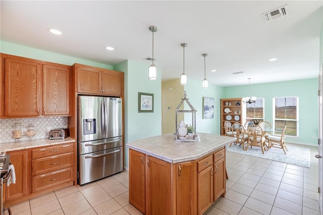 kitchen featuring a center island, light tile patterned floors, pendant lighting, and appliances with stainless steel finishes