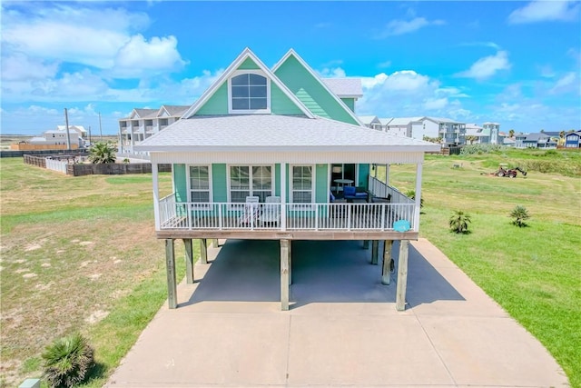 view of front of home with a carport, covered porch, and a front lawn