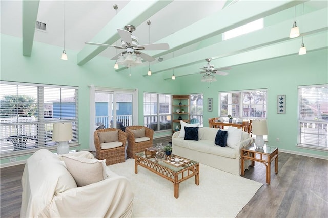 living room with beam ceiling, ceiling fan, a towering ceiling, and wood-type flooring