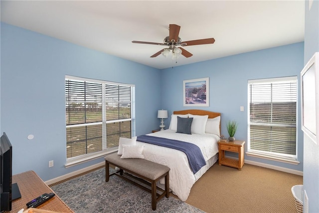 bedroom featuring carpet flooring, ceiling fan, and multiple windows