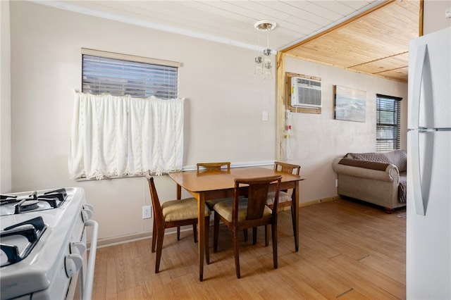 dining area featuring light wood-type flooring, an AC wall unit, and wood ceiling