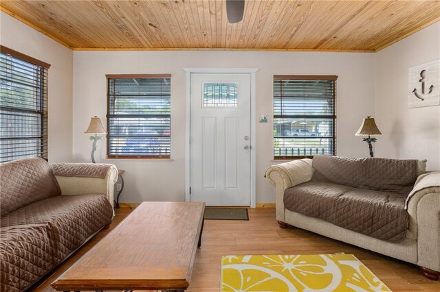 living room featuring wooden ceiling, light hardwood / wood-style flooring, and crown molding