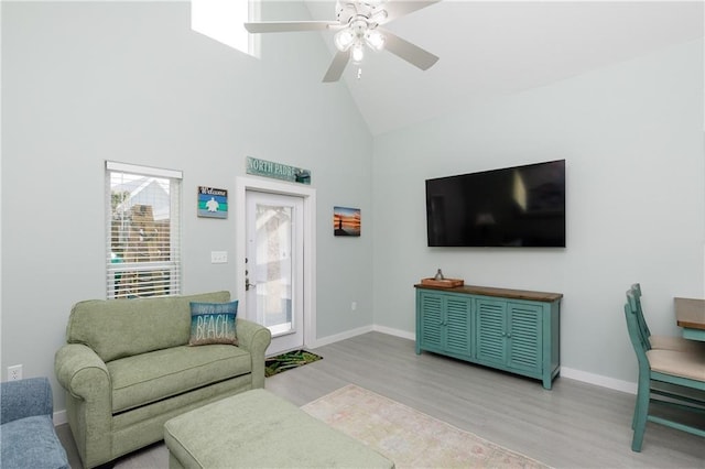 living room with hardwood / wood-style flooring, ceiling fan, and high vaulted ceiling