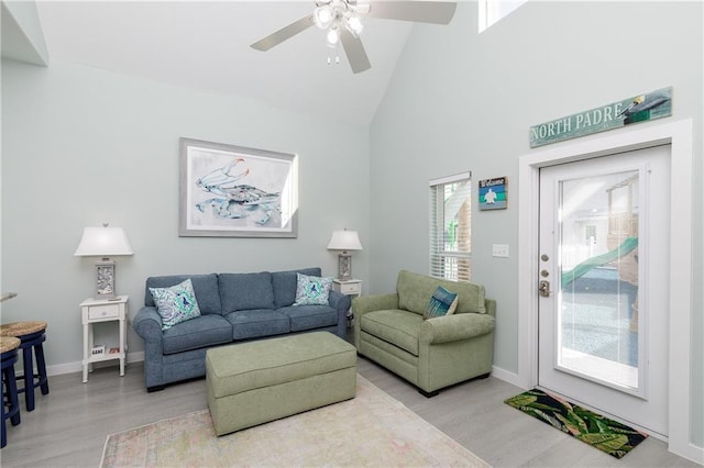 living room featuring plenty of natural light, ceiling fan, light wood-type flooring, and high vaulted ceiling