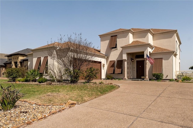 mediterranean / spanish home featuring stucco siding, driveway, a front lawn, and a garage