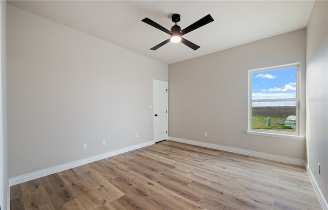 unfurnished room with light wood-style floors, ceiling fan, and baseboards