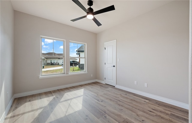 empty room with baseboards, ceiling fan, and light wood-style floors