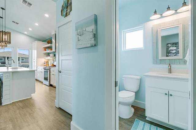 835 Ocean Side Dr, Port Aransas, TX 78373 - bathroom featuring plenty of natural light, wood finished floors, toilet, lofted ceiling, and vanity