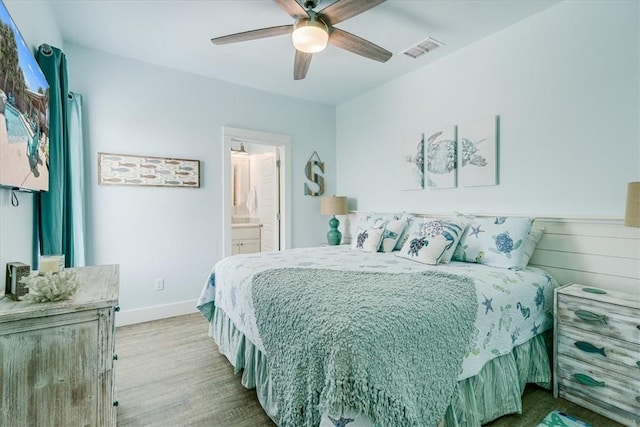 835 Ocean Side Dr, Port Aransas, TX 78373 - bedroom with wood finished floors, baseboards, ceiling fan, and ensuite bathroom