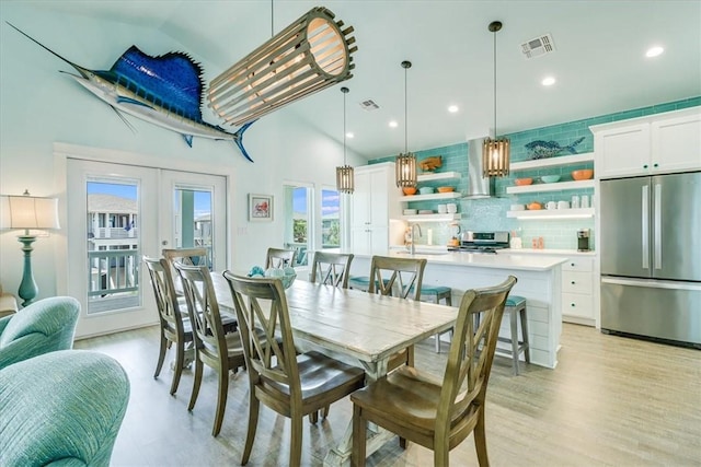 835 Ocean Side Dr, Port Aransas, TX 78373 - dining room featuring light wood finished floors, high vaulted ceiling, french doors, and recessed lighting