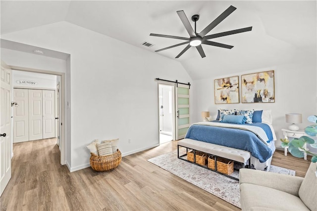 5025 Queens Ct, Corpus Christi, TX 78413 - bedroom with lofted ceiling, a barn door, light wood-style floors, and ceiling fan