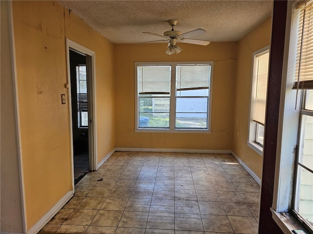 unfurnished room with baseboards, a textured ceiling, and a ceiling fan