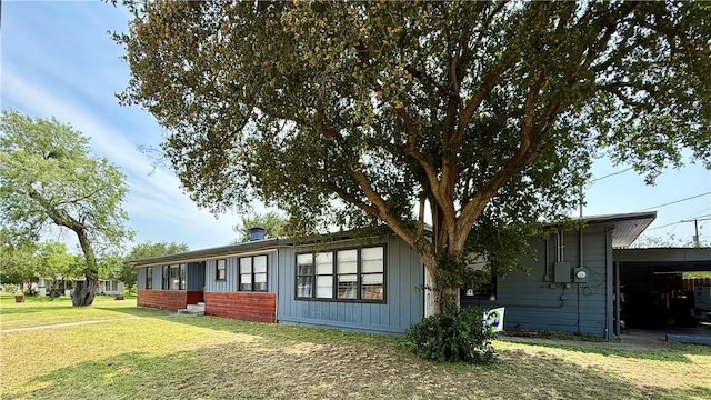 721 S 8th St, Kingsville, TX 78363 - view of side of property with an attached carport, a yard, and board and batten siding