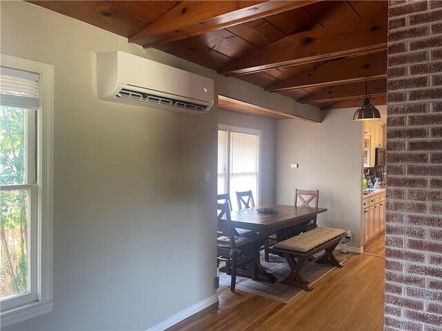 721 S 8th St, Kingsville, TX 78363 - dining area featuring a wall unit AC, light wood-type flooring, healthy amount of natural light, wood ceiling with exposed beams, and baseboards