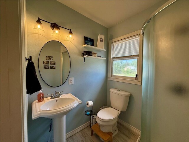 721 S 8th St, Kingsville, TX 78363 - full bath featuring toilet, wood finished floors, baseboards, and a shower