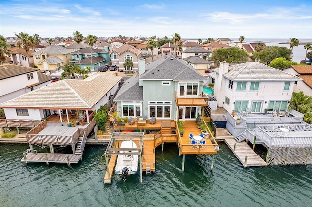 dock area with a residential view, boat lift, and a water view