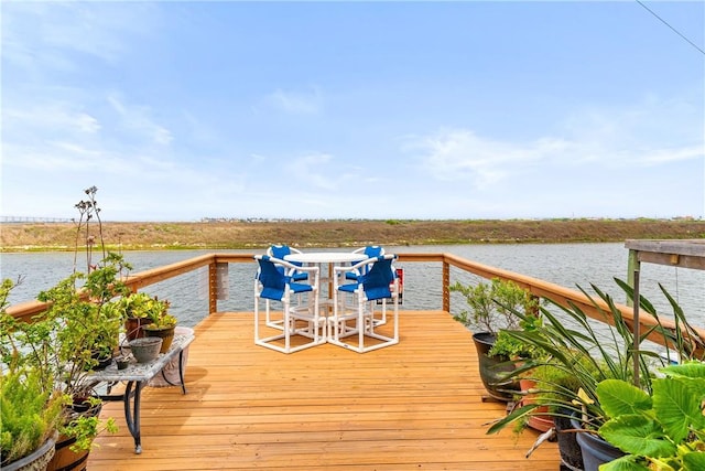 dock area featuring outdoor dining space and a deck with water view