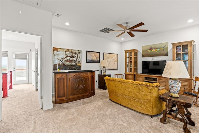 living room with light colored carpet, ceiling fan, and visible vents