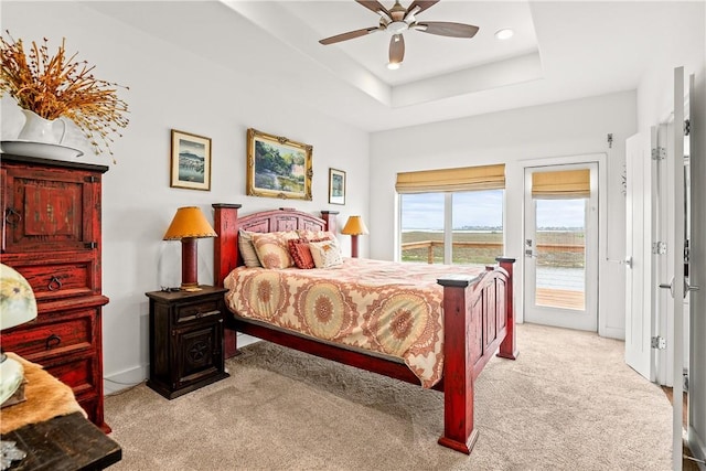 bedroom with a raised ceiling, carpet, ceiling fan, and access to exterior