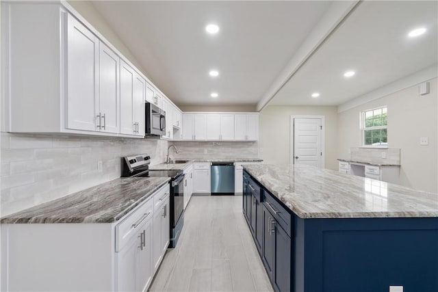 4938 Mable St, Corpus Christi, TX 78411 - kitchen with appliances with stainless steel finishes, recessed lighting, white cabinets, a center island, and light stone counters