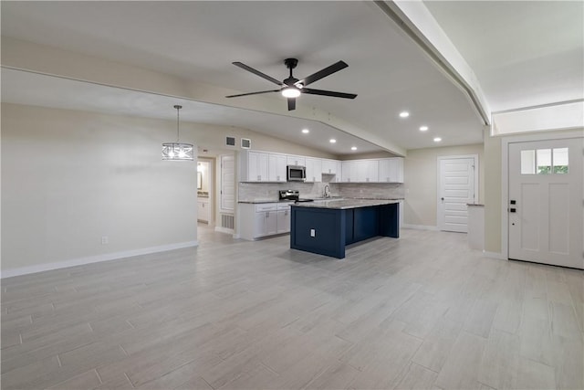 4938 Mable St, Corpus Christi, TX 78411 - kitchen featuring appliances with stainless steel finishes, a sink, lofted ceiling, white cabinetry, and open floor plan