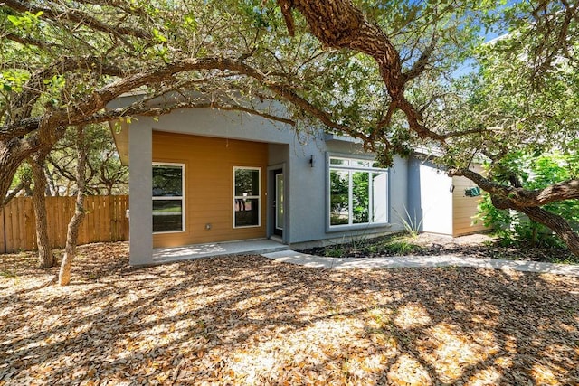 110 Forest Hls, Rockport, TX 78382 - back of property with stucco siding, fence, and a patio area