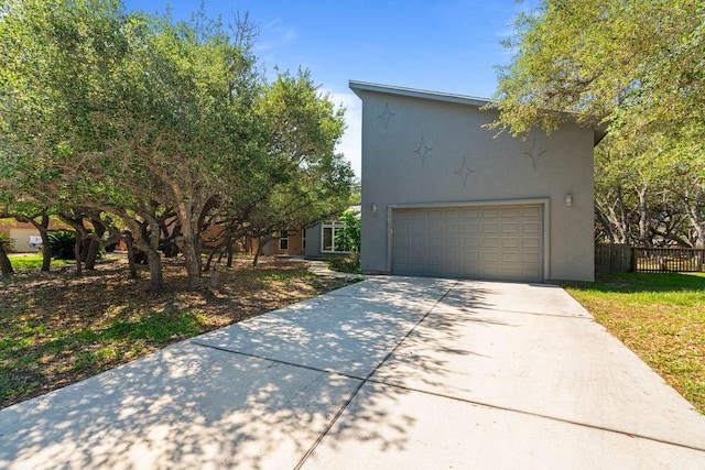 110 Forest Hls, Rockport, TX 78382 - view of front of house featuring driveway, stucco siding, fence, and a garage