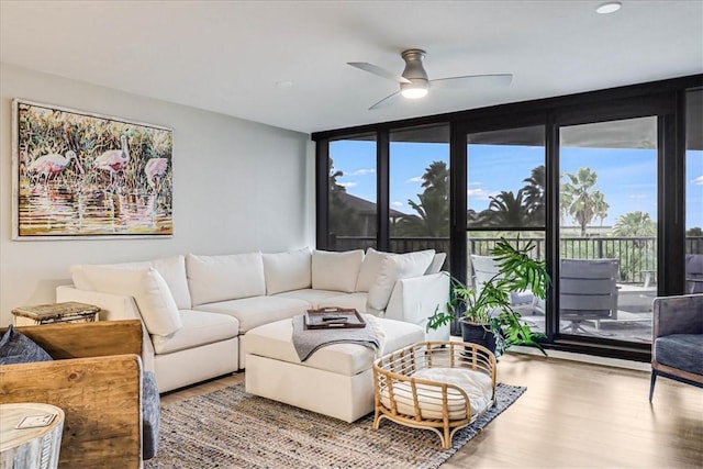 living room with light hardwood / wood-style floors, expansive windows, and ceiling fan