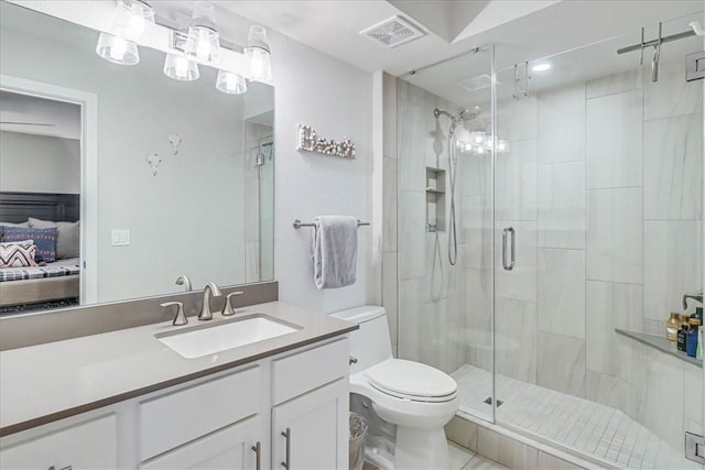 bathroom featuring tile patterned floors, vanity, toilet, and a shower with shower door