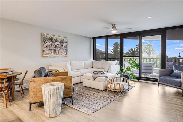 living room featuring floor to ceiling windows, ceiling fan, and light hardwood / wood-style floors