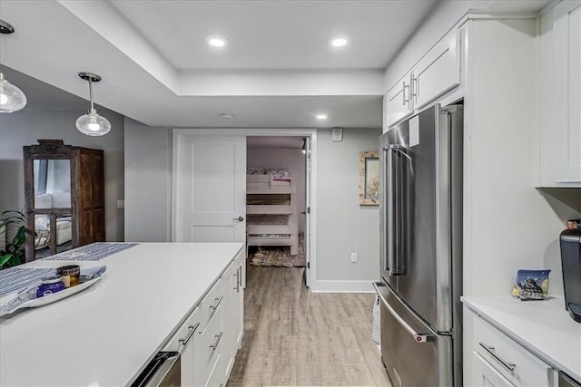 kitchen with white cabinetry, pendant lighting, high end refrigerator, and light wood-type flooring