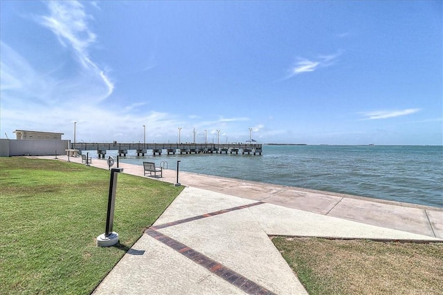 dock area with a water view and a yard