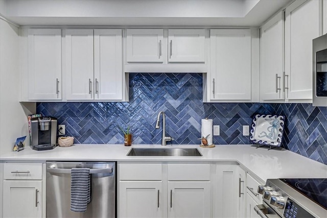 kitchen with white cabinetry, stainless steel appliances, sink, and decorative backsplash