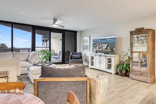 living room featuring hardwood / wood-style flooring, expansive windows, and ceiling fan