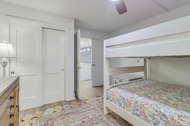 bedroom featuring light hardwood / wood-style floors, ceiling fan, and a closet