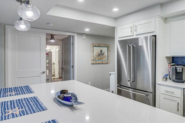 kitchen with decorative light fixtures, high quality fridge, and white cabinets