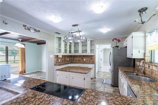 kitchen featuring white cabinets, a healthy amount of sunlight, sink, and a kitchen island