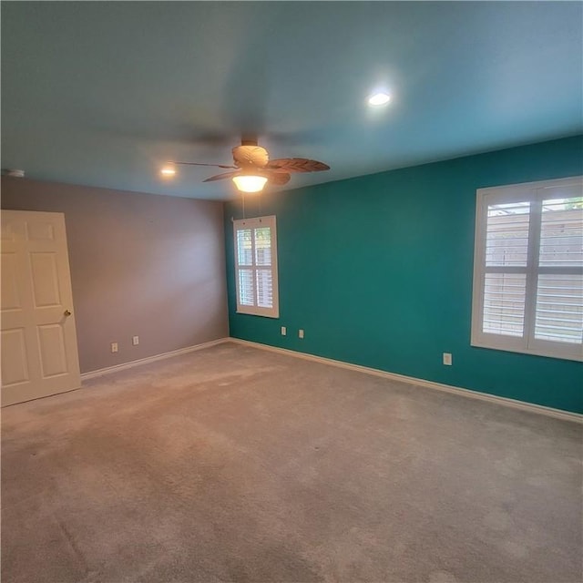 carpeted spare room with recessed lighting, ceiling fan, and baseboards