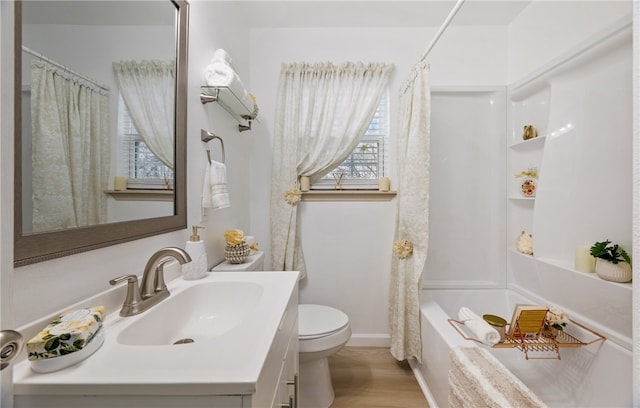 full bath featuring toilet, shower / tub combo, wood finished floors, vanity, and baseboards