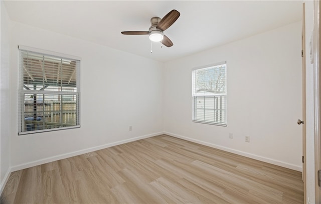 unfurnished room featuring a ceiling fan, light wood-style flooring, and baseboards