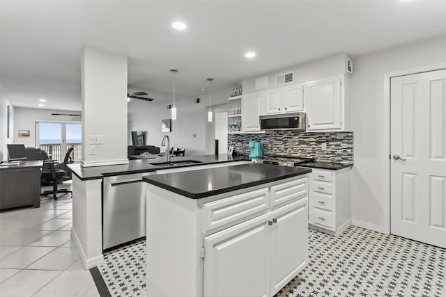 5973 State Highway 361 Unit 436, Port Aransas, TX 78373 - kitchen featuring stainless steel appliances, dark countertops, a center island, backsplash, and open shelves