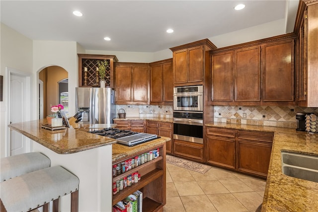 6001 King Trl, Corpus Christi, TX 78414 - kitchen with appliances with stainless steel finishes, tasteful backsplash, light stone counters, a breakfast bar area, and light tile patterned floors
