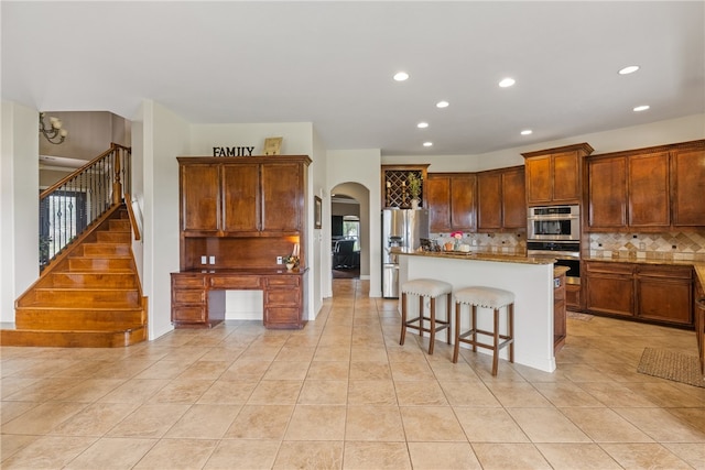 6001 King Trl, Corpus Christi, TX 78414 - kitchen featuring stainless steel appliances, arched walkways, light tile patterned flooring, tasteful backsplash, and recessed lighting