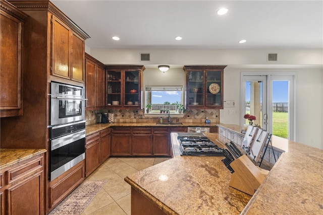6001 King Trl, Corpus Christi, TX 78414 - kitchen with backsplash, light tile patterned floors, recessed lighting, and glass insert cabinets