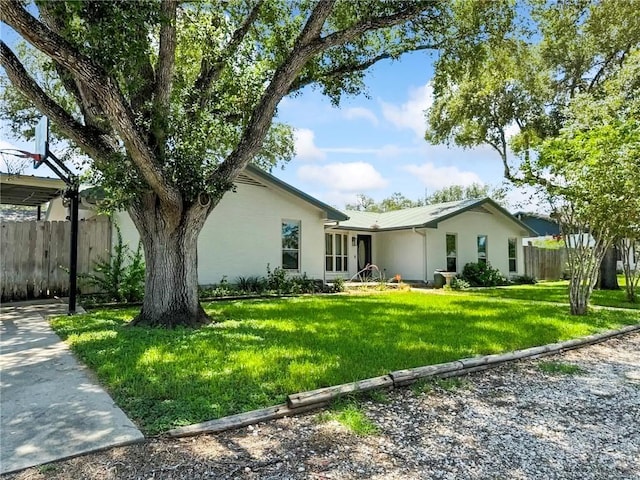 view of front of property featuring a front yard, fence, and stucco siding