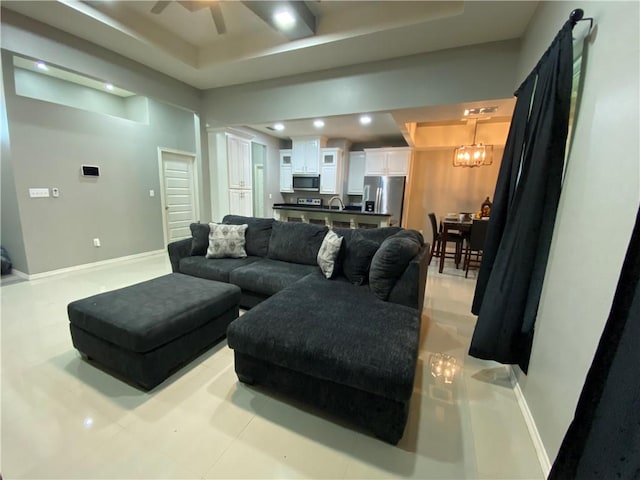 living room featuring ceiling fan with notable chandelier