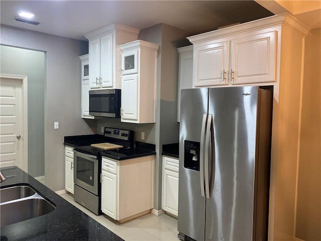 kitchen with light tile patterned floors, white cabinetry, sink, and appliances with stainless steel finishes